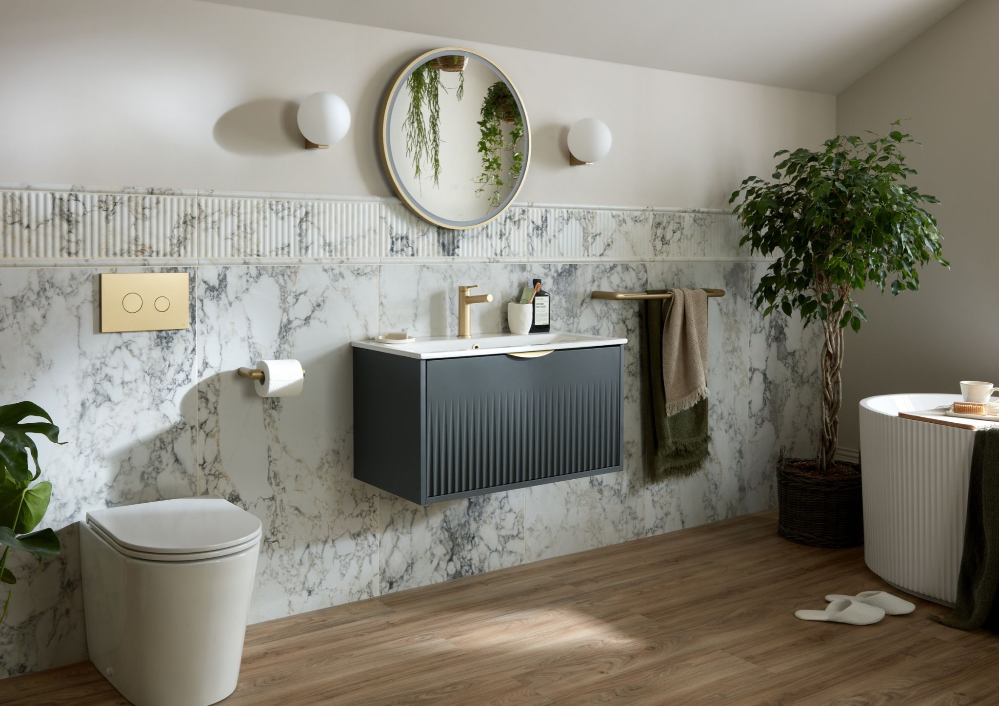 Modern bathroom with fluted vanity, round mirror and satin brass brassware