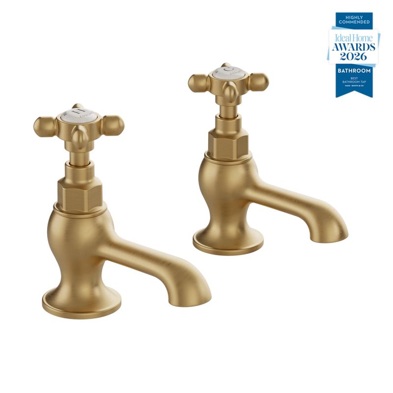 Booth & Co. Axbridge basin pillar taps with cross handles, finished in brushed brass with crackled off-white ceramic accents.