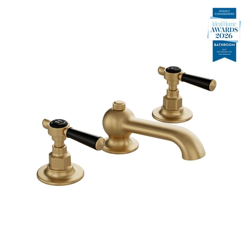 Booth & Co. Axbridge basin mixer tap with a pop up basin waste and lever handles, finished in brushed brass with black ceramic accents.