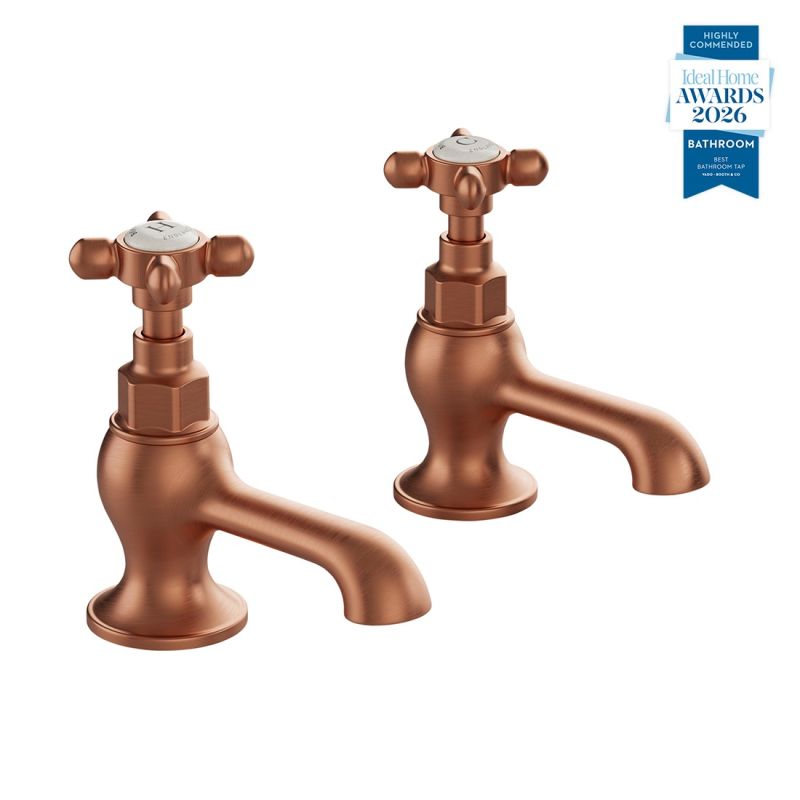 Booth & Co. Axbridge basin pillar taps with cross handles, finished in brushed brass with black ceramic accents.