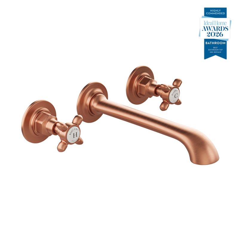 Booth & Co. Axbridge wall mounted basin mixer tap with cross handles, finished in brushed brass with black ceramic accents.