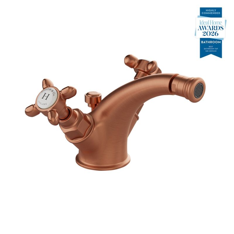 Booth & Co. Axbridge mono bidet mixer with a pop up basin waste and cross handles, finished in brushed brass with black ceramic accents.