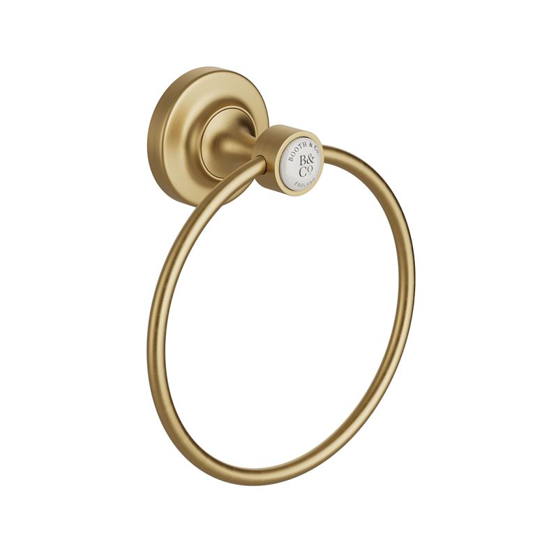 Booth & Co. towel ring, finished in brushed brass with crackled off-white ceramic accents. Booth & Co. towel ring, finished in brushed brass with crackled off-white ceramic accents.