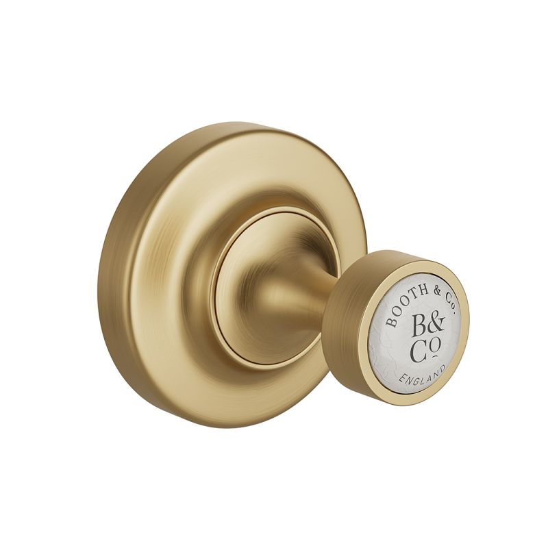 Booth & Co. robe hook, finished in brushed brass with crackled off-white ceramic accents. Booth & Co. robe hook, finished in brushed brass with crackled off-white ceramic accents.