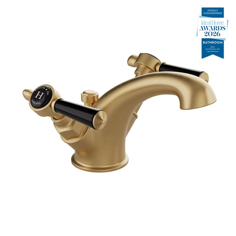 Booth & Co. Axbridge Mono basin mixer tap with a pop up basin waste and lever handles, finished in brushed brass with black ceramic accents.