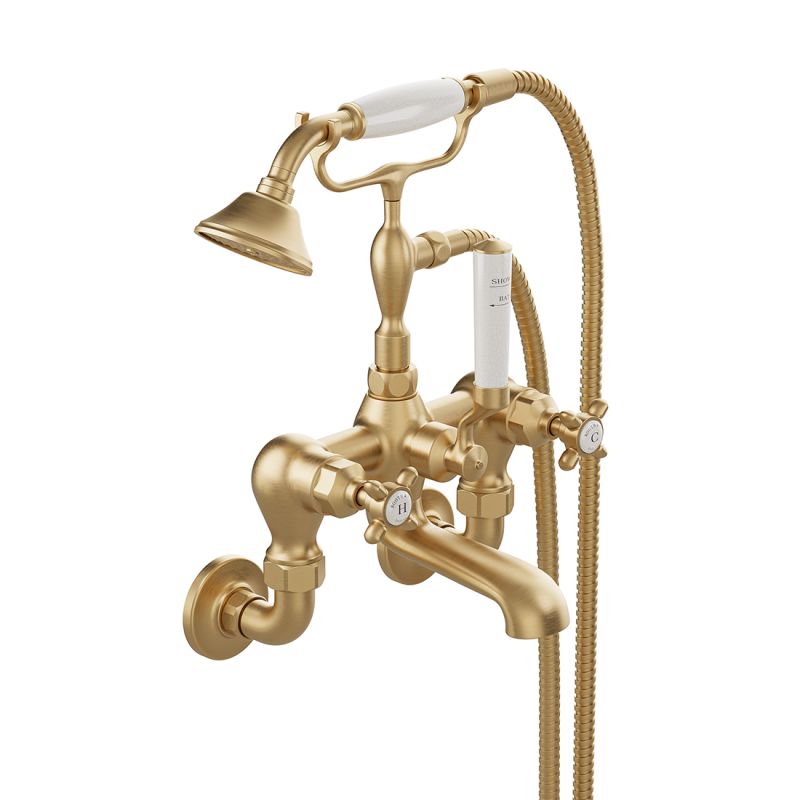 Booth & Co. Axbridge wall mounted bath shower mixer tap with shower kit and cross handles, finished in brushed brass with crackled off-white ceramic accents.