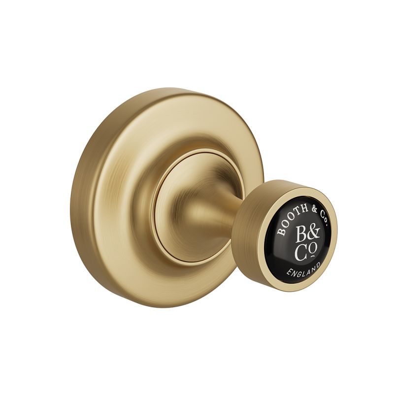 Booth & Co. robe hook, finished in brushed brass with black ceramic accents.