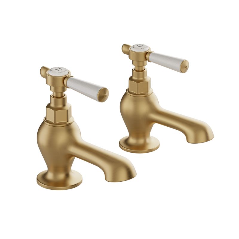 Booth & Co. Axbridge bath pillar taps with lever handles, finished in brushed brass with crackled off-white ceramic accents.