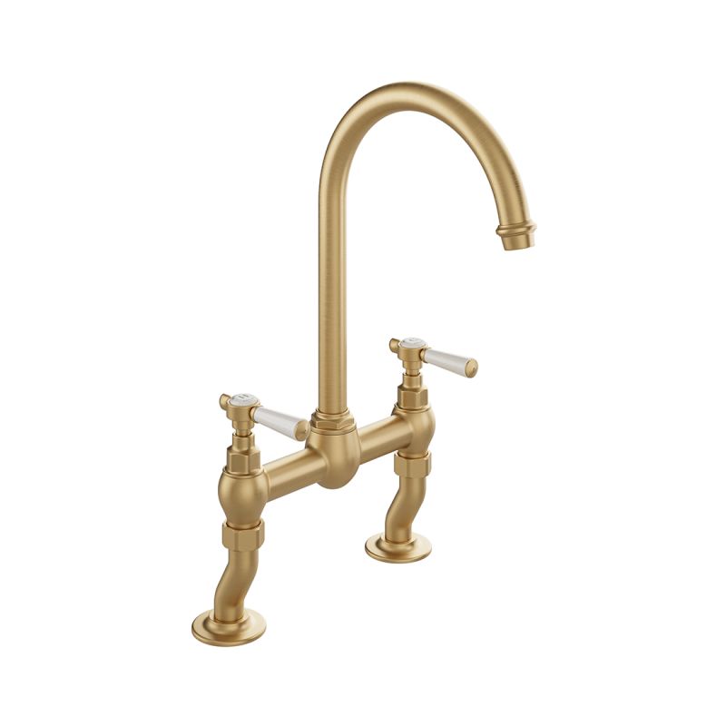 Booth & Co. Axbridge bridge kitchen tap mixer with lever handles, finished in brushed brass with crackled off-white ceramic accents.